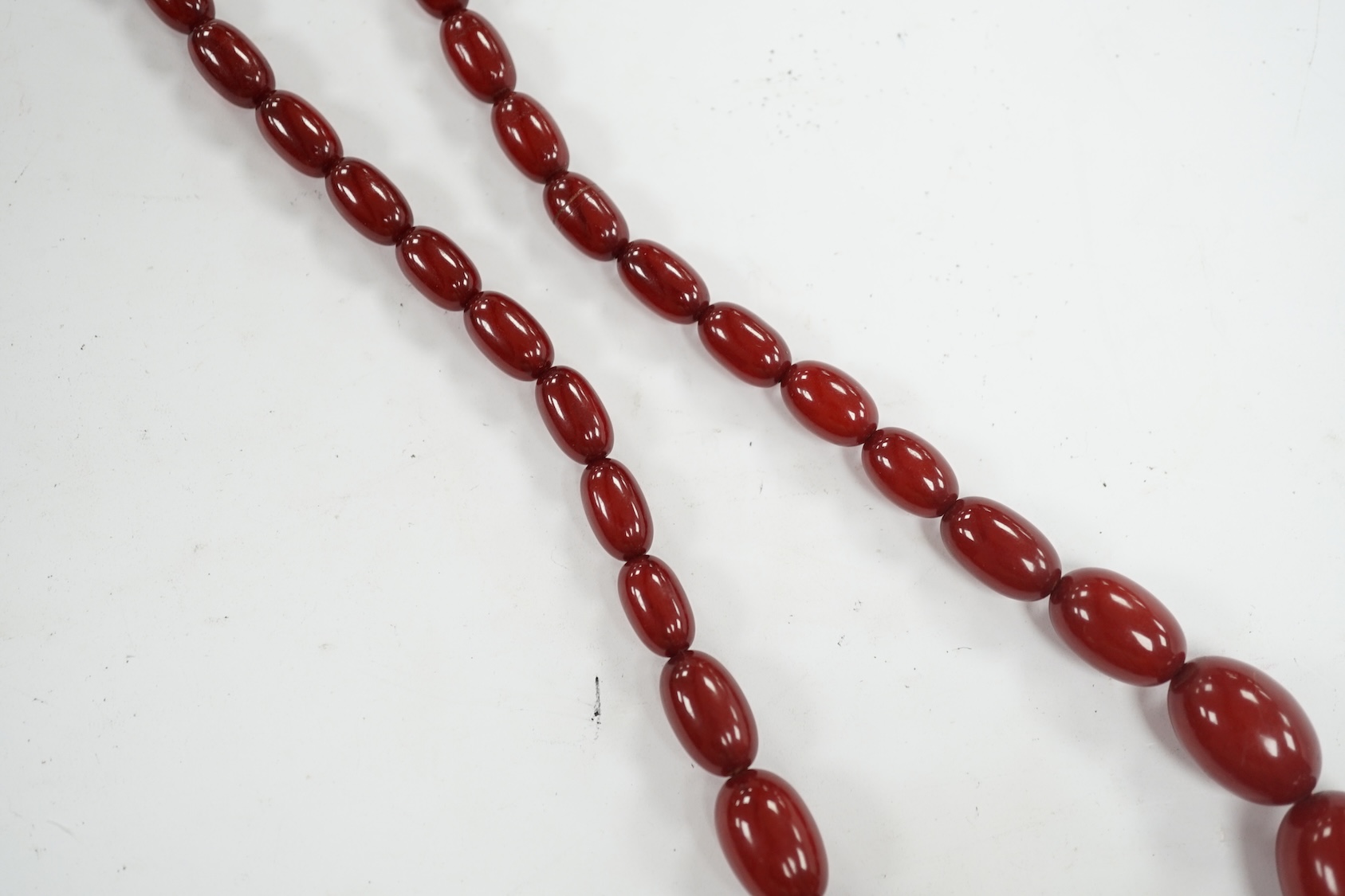 A single strand graduated simulated cherry amber bead necklace, 68cm, gross weight 52 grams. Condition - fair to good